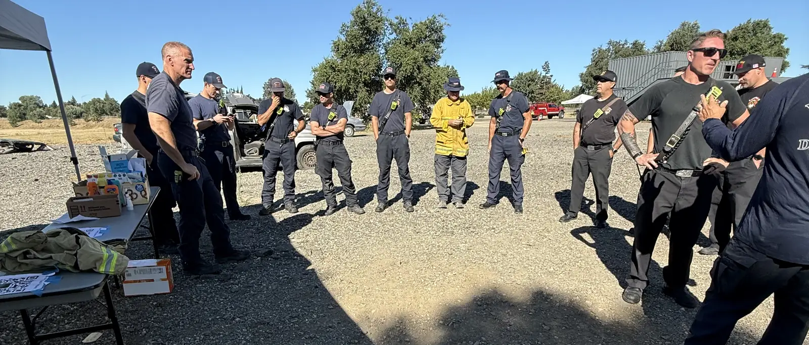 Fire department operators in an off-road apparatus training briefing, reviewing recovery gear.